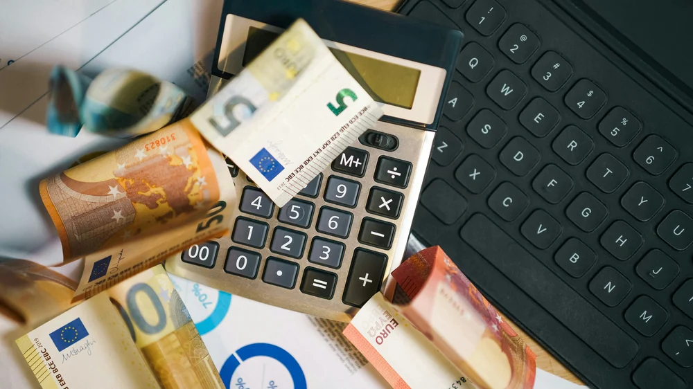 Calculadora y billetes de euro sobre una mesa