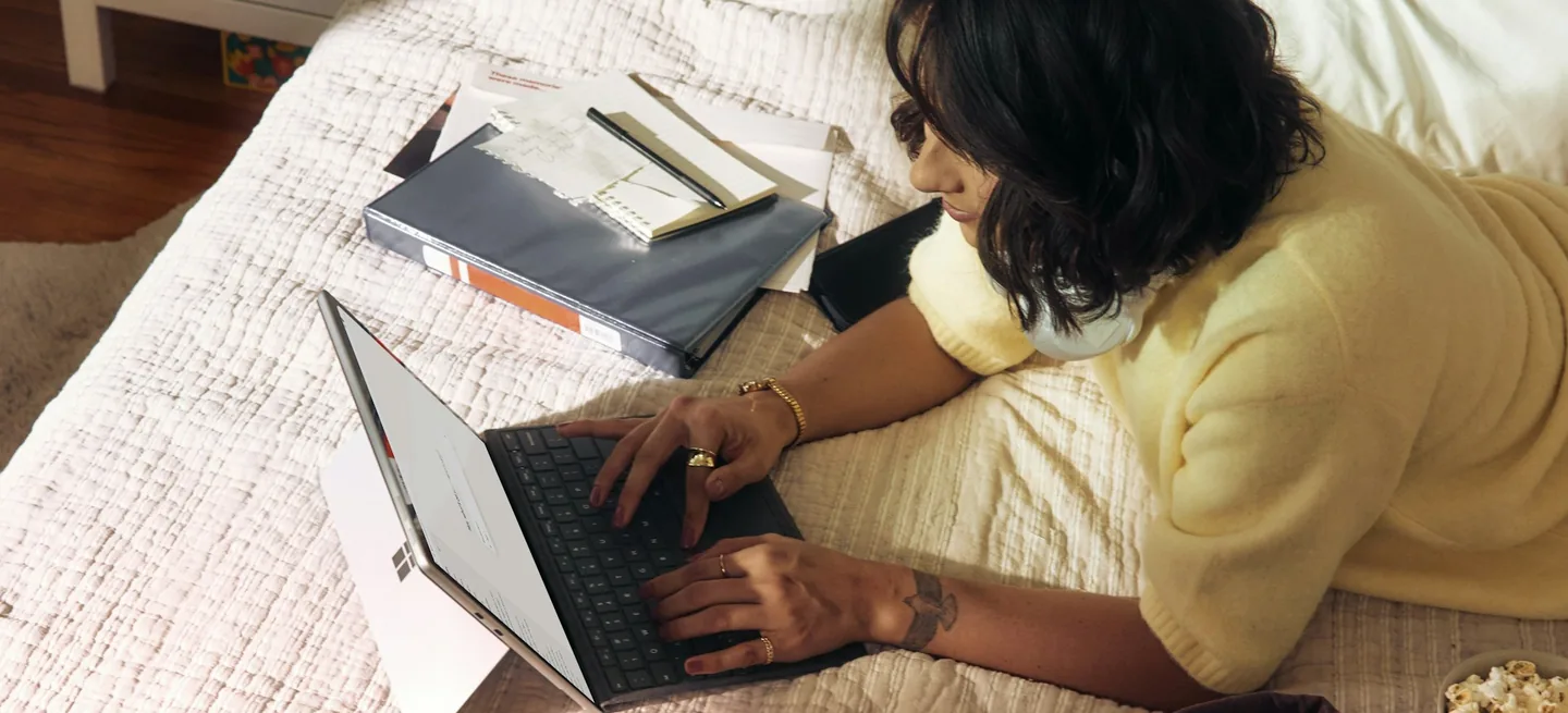 Persona revisando facturas y documentos en el portátil desde casa